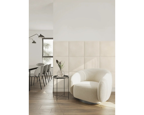 Moderne woonkamer met vierkante gepolsterde wandpanelen, een ronde fauteuil en een eethoek in een lichte, georganiseerde ruimte.