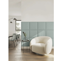 Moderne woonkamer met vierkante wandpanelen, een witte bouclé fauteuil, bijzettafel met vaas en eethoek op de achtergrond.