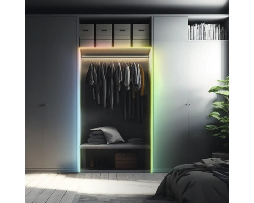 Ledstrip op een kledingkast in een georganiseerde slaapkamer. Meerkleurige verlichting aan het frame van de kast.