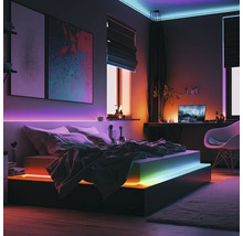 Moderne slaapkamer met slimme LED-strip verlichting onder het bed, langs de muur en het plafond, met kleurrijke lichteffecten.
