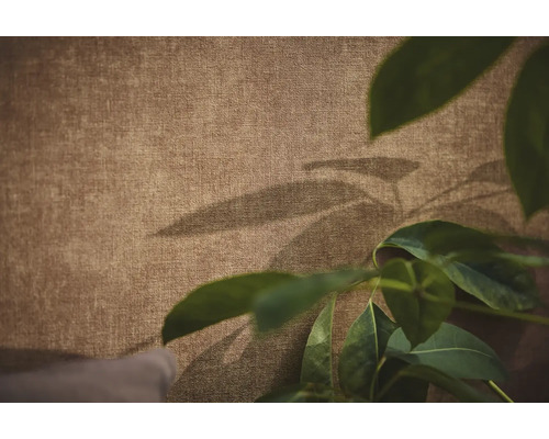 Gestructureerd behang met linnenlook en decoratieve schaduwen van bladeren.