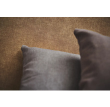 Detailopname van behang met textiellook en twee decoratieve kussens.