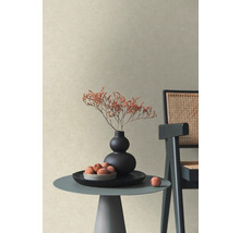 Gestructureerd vliesbehang in beige in een moderne woonkamer met bijzettafel, vaas met droogbloemen en stoel.