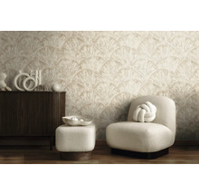 Moderne woonkamer met behang met een waaierpatroon, een donkerhouten dressoir en een lichte fauteuil met hocker.