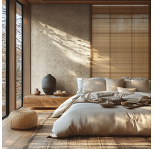 Lichte slaapkamer in Japanse stijl met patroonbehang, een laag houten bed, een rotan poef en wandpanelen van natuurlijke vezels.