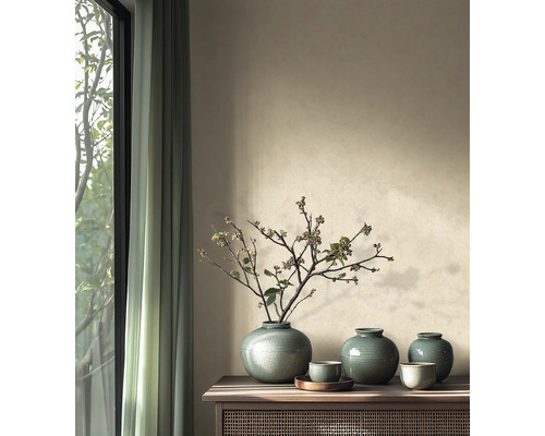 Lichte, georganiseerde inrichting met keramische vazen, takken en schalen op een houten consoletafel naast een raam met gordijnen.