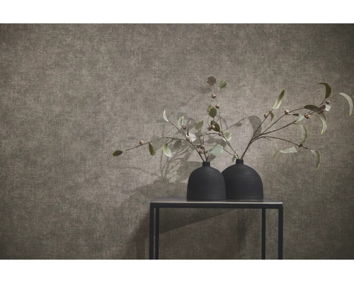 Gestructureerd behang met linnenlook in een modern ingerichte kamer met twee zwarte vazen op een tafel.