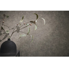 Gestructureerd behang met linnenlook met een zwarte vaas en takken op de voorgrond.