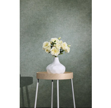 Groen gestructureerd vliesbehang met textieloptiek achter een bijzettafel met bloemenvaas.