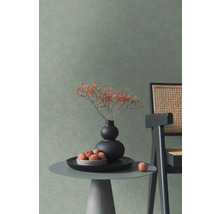 Wand met getextureerd behang in een modern ingerichte kamer met bijzettafel, vaas en stoel met vlechtwerk.