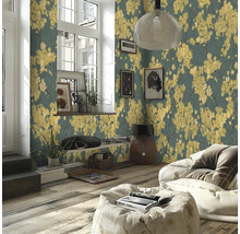 Moderne woonkamer met vliesbehang met gele bloesem op een donkere achtergrond, houten vloer en lichte zitzak.