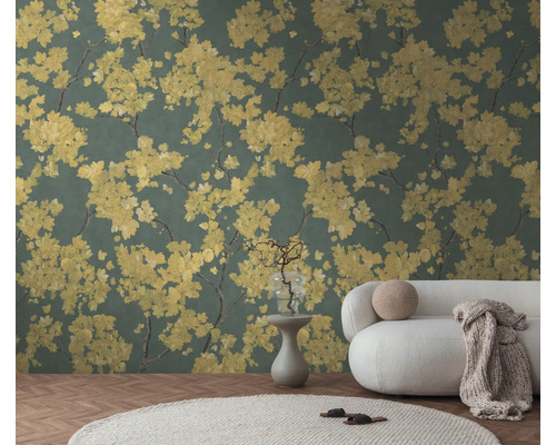 Behang met geel bloemenpatroon op een donkergroene achtergrond in een lichte woonkamer met een witte bank en een rond tapijt.