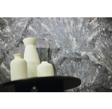 Gestructureerd behang met abstract patroon in grijs en wit achter drie witte vazen.