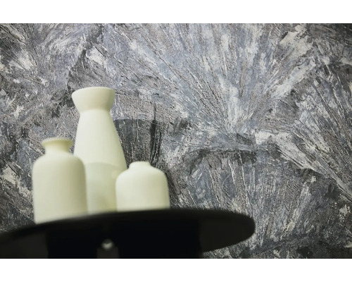 Gestructureerd behang met abstract patroon in grijs en wit achter drie witte vazen.