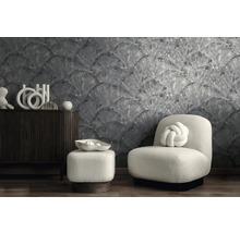 Moderne kamer met grijs structuurbehang met waaiermotief, donker houten dressoir en witte fauteuil met knoopkussen.