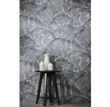 Behang met textuur en waaiermotief, met een zwarte kruk en drie witte vazen op de voorgrond.