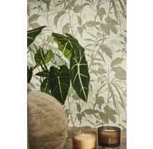 Vliesbehang met botanisch bladpatroon in een sfeervolle setting met Alocasia plant en kaarsen.