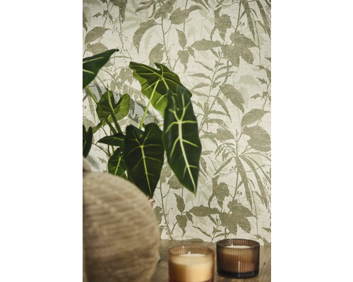 Vliesbehang met botanisch bladpatroon in een sfeervolle setting met Alocasia plant en kaarsen.