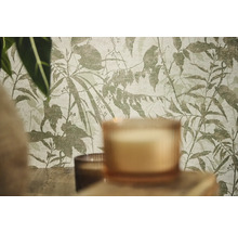 Vliesbehang met botanisch blad- en takkenpatroon in een kamer met kaarsen en planten.