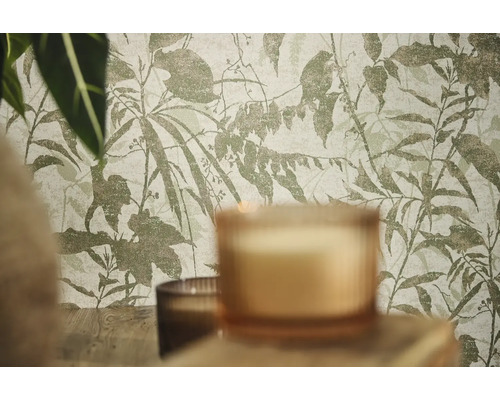 Vliesbehang met botanisch blad- en takkenpatroon in een kamer met kaarsen en planten.
