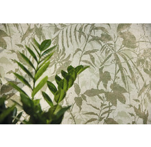 Vliesbehang met botanisch bladmotief en een plant op de voorgrond.