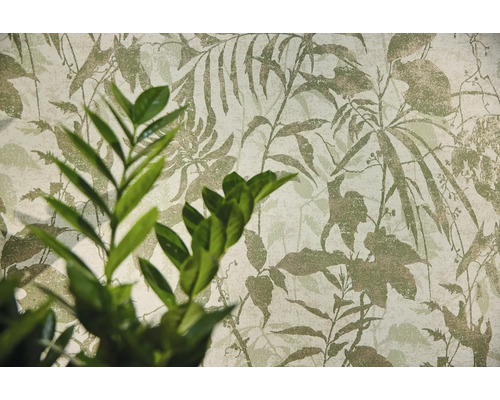 Vliesbehang met botanisch bladmotief en een plant op de voorgrond.