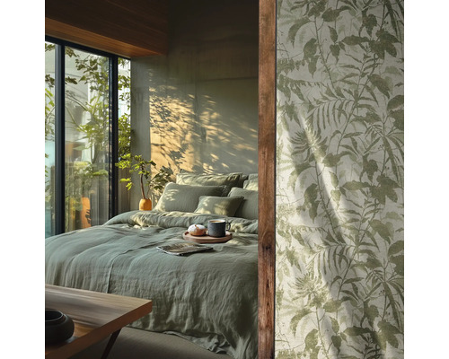 Slaapkamer met lichtgroen linnen beddengoed en behang met botanisch bladerpatroon voor een zonnig raam.
