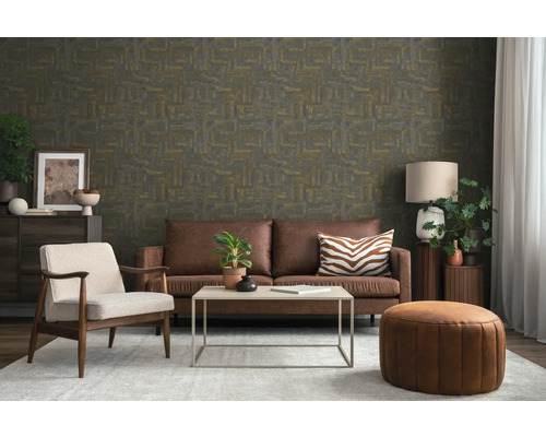 Woonkamer met behang met patroon, bruine leren bank, lichte fauteuil, salontafel en vloerkleed. Modern interieur in aardetinten.