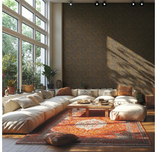 Lichte, ruime woonkamer met een grote modulaire bank, een oosters tapijt, een houten salontafel en donker behang met textuur.