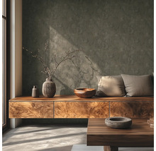 Moderne woonkamer met gestructureerde donkergrijze muur, houten dressoir, decoratieve vazen, houten kom en kussens bij daglicht.