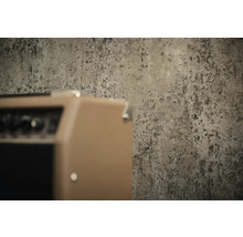 Gestructureerd behang met betonlook in industriële stijl achter een versterker.