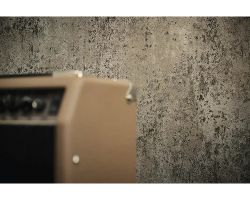 Gestructureerd behang met betonlook in industriële stijl achter een versterker.