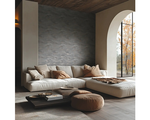 Moderne woonkamer met structuurwand, hoekbank, lage houten tafel en een groot boogvenster met uitzicht op een boom.