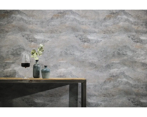 Gestructureerd vliesbehang met steenlook op een muur achter een houten tafel met decoratieve vazen en een wijnglas.