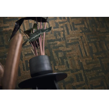 Vliesbehang met abstract geometrisch patroon en textuur op een muur achter een kamerplant.