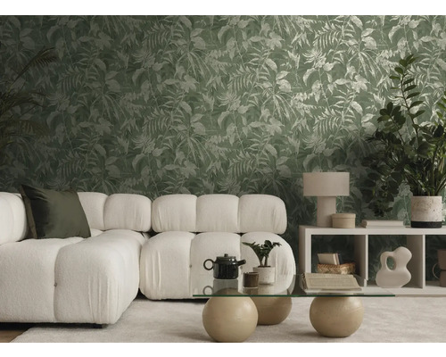 Lichte, moderne woonkamer met witte bank, glazen tafel en vliesbehang met groen bladerpatroon in tropische stijl.