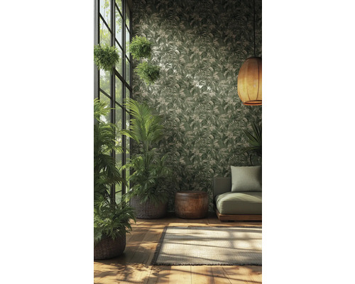 Vliesbehang met tropisch bladpatroon in groen en crème in een lichte kamer met kamerplanten, groene bank en gevlochten hanglamp.