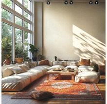 Lichte woonkamer met grote modulaire bank, houten salontafel en oosters tapijt voor een grote raampartij met plafondspots.