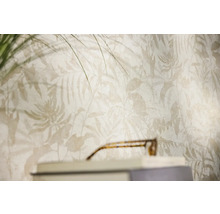 Vliesbehang met tropisch bladpatroon en varenmotieven in een lichte woonkamer.