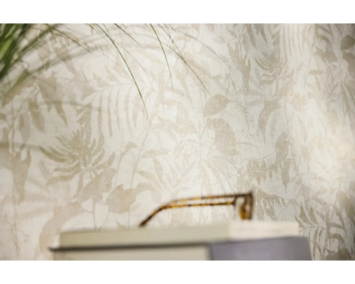 Vliesbehang met tropisch bladpatroon en varenmotieven in een lichte woonkamer.