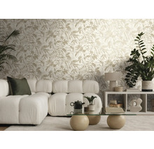 Licht ingerichte woonkamer met vliesbehang met bladmotief, een witte modulaire bank van boucléstof en een glazen tafel met stenen poten.