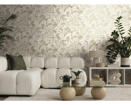 Licht ingerichte woonkamer met vliesbehang met bladmotief, een witte modulaire bank van boucléstof en een glazen tafel met stenen poten.