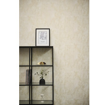 Vliesbehang met textuurlook op een muur achter een zwart metalen rek in een lichte, modern ingerichte kamer.