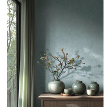 Decoratieve keramieken vazen met craquelé glazuur en schalen op een houten dressoir voor een gestructureerde muur.