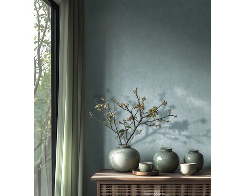 Decoratieve keramieken vazen met craquelé glazuur en schalen op een houten dressoir voor een gestructureerde muur.