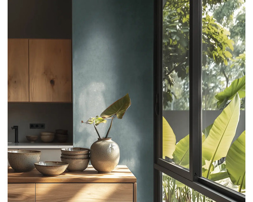 Moderne keuken met houten kasten, keramieken schalen en een vaas op een houten oppervlak naast een raam met uitzicht op groene planten.