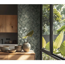 Behang met bladmotief in een lichte keuken met houten meubels, keramieken schalen en een vaas voor een raam met uitzicht op de natuur.