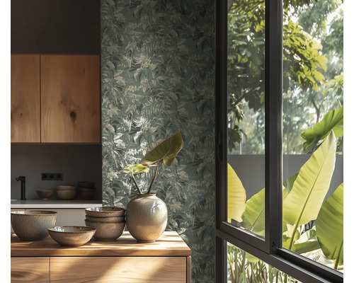 Behang met bladmotief in een lichte keuken met houten meubels, keramieken schalen en een vaas voor een raam met uitzicht op de natuur.