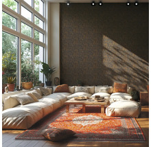 Ruime woonkamer met donker vliesbehang met geometrisch patroon, witte modulaire bank, oosters tapijt en grote ramen.