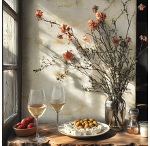 Rustieke tafel bij het raam met witte wijn, olijven, feta, tomaten en een vaas met droogbloemen tegen een getextureerde muur.